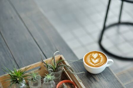 Coffee cup with latte art on the wood table.の写真素材