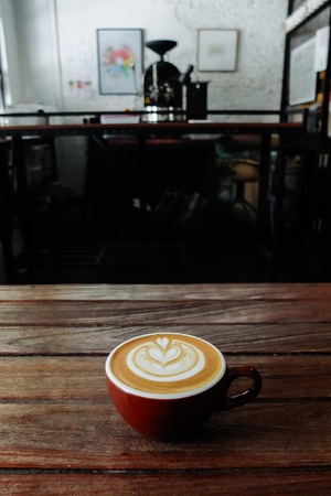 Coffee cup with latte art on the wood table.の写真素材