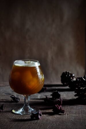 Iced black coffee on wooden floor and dark tone decoration.
