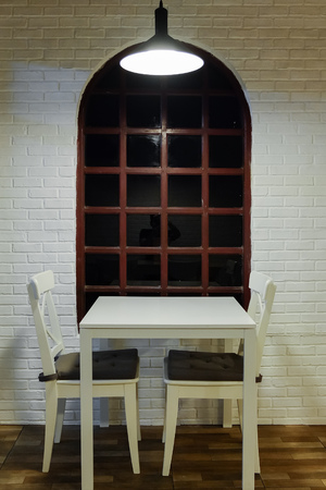 Cafe seating area with wooden table and chairs in cottage styleのeditorial素材