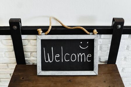 Welcome sign made by galvanized iron on wood table.