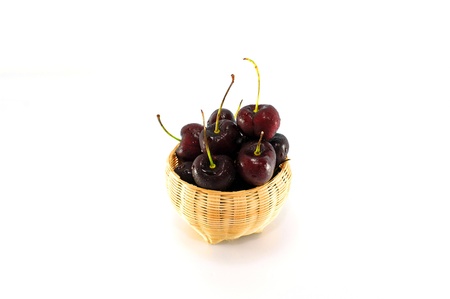 Cherries in a basket on white background.