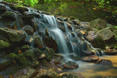 Beautiful of small waterfall flowing over the rock  in the forest.