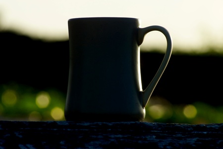 Silhouettes on sunrise coffee at the beach in the morning の写真素材