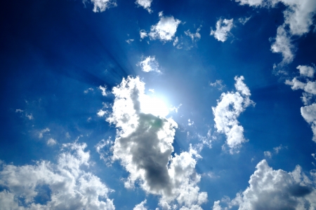 Blue sky with Altocumulus castellanus cloud and sun closeup