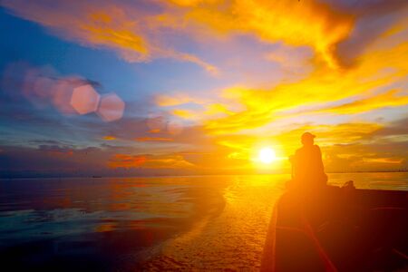Lonely men silhouettes on sunset sky beautiful lagoon