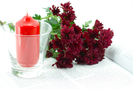 Candle and chrysanthemum on bookの写真素材