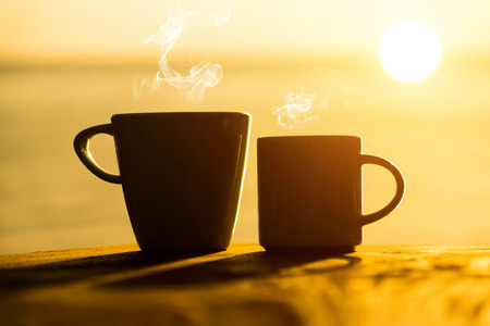 Silhouettes of morning coffee on the lake.の写真素材