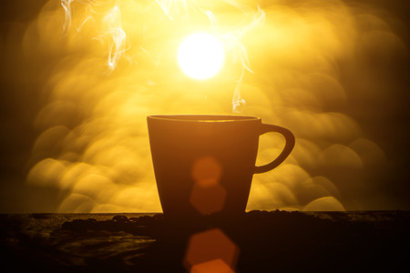 Silhouettes of morning coffee on the lake.の写真素材