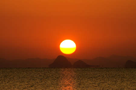 Sunset sky and big sun over the lake.の写真素材