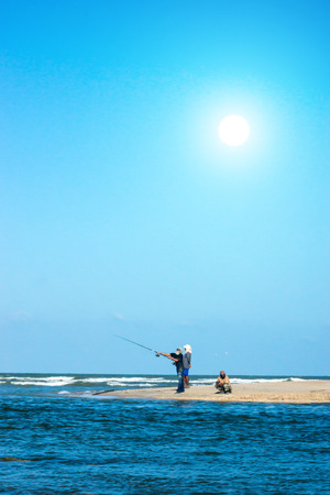 People fishing at the coast.の写真素材