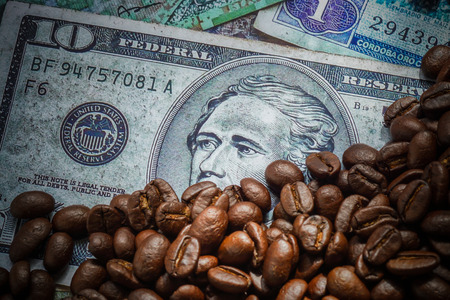 roasted coffee beans on money background.の写真素材