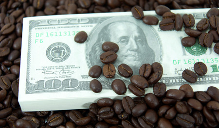 roasted coffee beans on money background.の写真素材