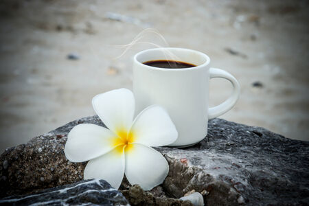 Coffee on the beach and frangipani flower.の写真素材