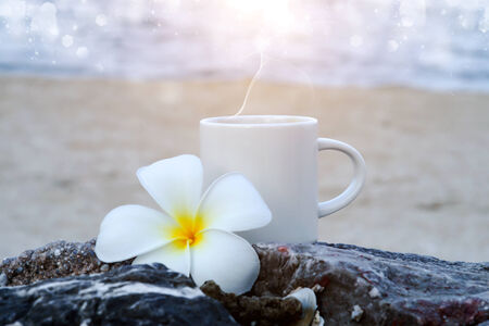Coffee on the beach and frangipani flower.の写真素材