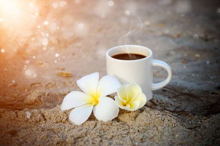Coffee on the beach and frangipani flower.の写真素材