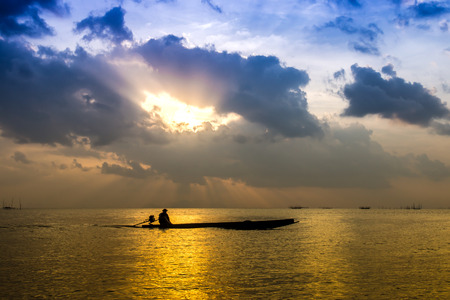 fishman and sunset sky over lake, Thailand.の写真素材