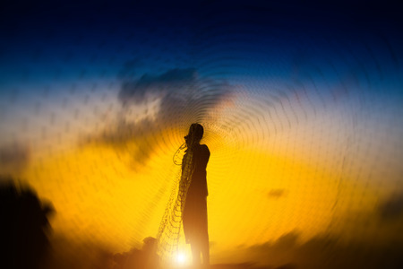 Casting a silhouette at sunset on the lake, Thailand.