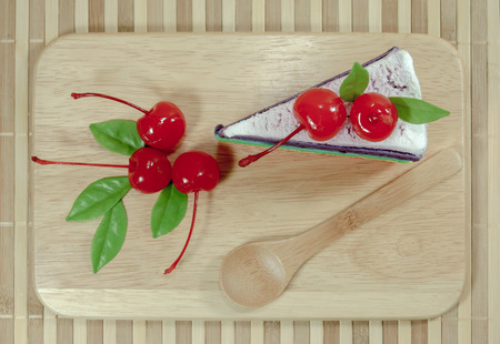 Rainbow cake with cherriesの写真素材