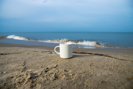 White coffee mug on the beach.の写真素材
