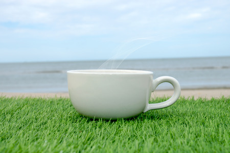 White coffee cup on the grass in beachの写真素材