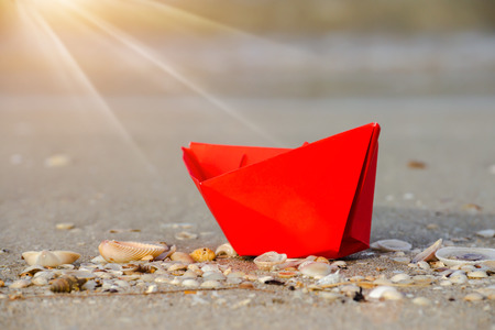 Red paper boats on beach outdoors.の写真素材
