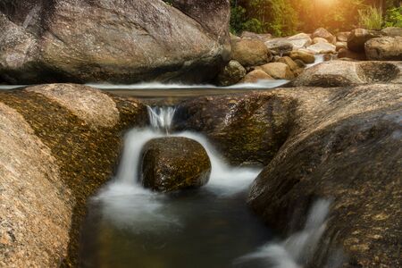 Small Waterfall and rock in tropical forest.  (Un-focus image)の写真素材