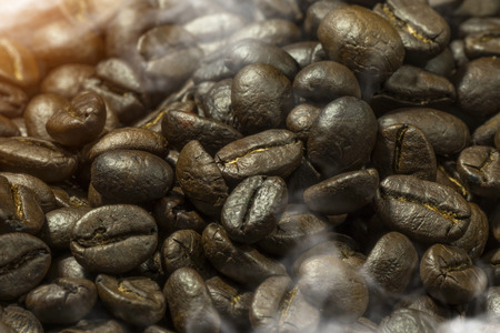 Close-up of hot coffee beans with light and steam.の写真素材