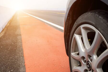 Close up of wheel  car parking on the asphalt road with sunlight.の写真素材