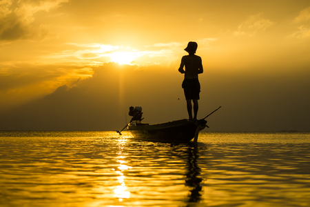 Silhouettes of fisherman at the lake with sunset, Thailand.の写真素材