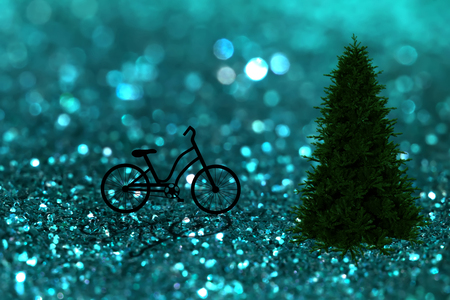 Silhouette of a bicycle in christmas night in green sparkling glitter bokeh background and pine tree.の写真素材