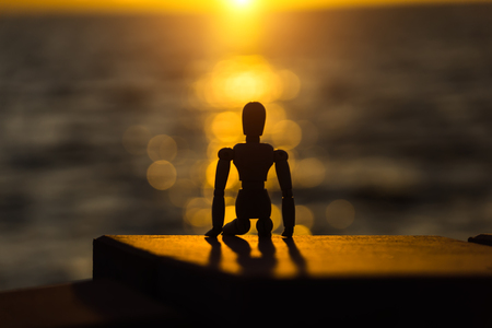 Silhouettes of wooden models feel lonely at sunset.の写真素材