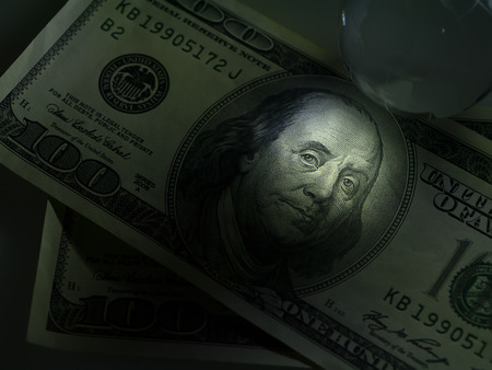 Low key image close up of face on dollar money.