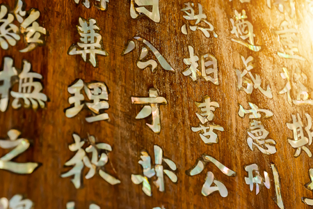 Close up Old Chinese characters on ancient wood with light.のeditorial素材