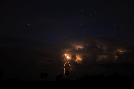 Low key image, The sky is cloudy and lightning in the night with star.の写真素材