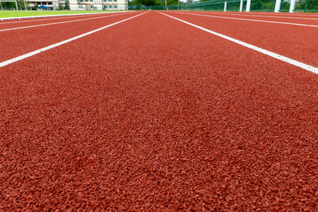 Red treadmill with white line at the stadium.