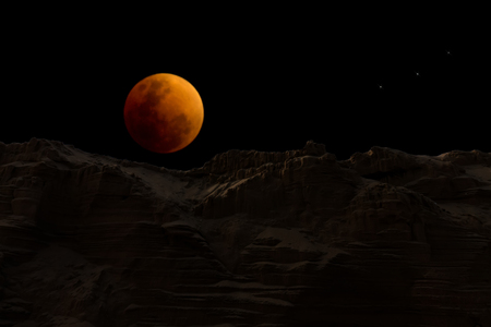 The super blue blood moon in the dark night oversand mountain.
