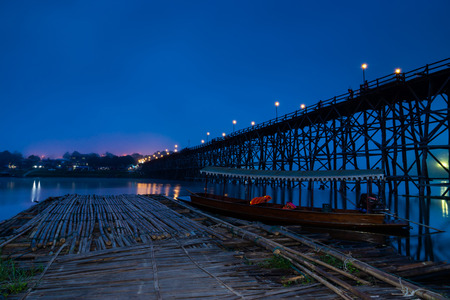 The Mon bridge in blue sky before sunrise with bamboo floating and boat travel at Songkaria river, Landmark of Sangkhla Buri Distric, Kanchanaburi Province., The western travel of Thailand.の写真素材