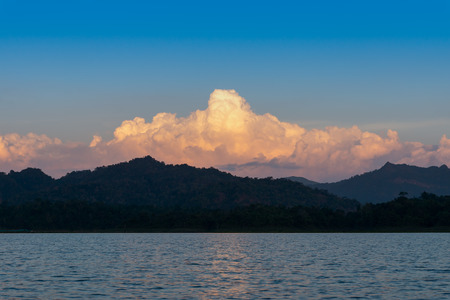 The cloud with sunlight above the silhouette mountain at the river of Sangkhla Buri district, Kanchanaburi. The water travel in western of Thailand.の写真素材