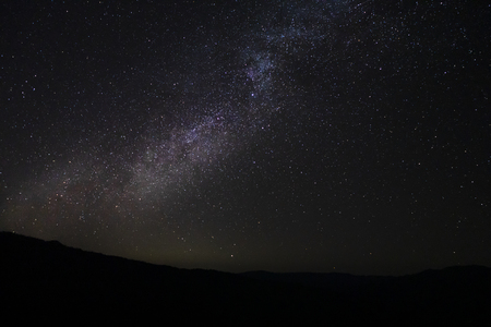 The night sky with milky way and stardust above the black mountain.の写真素材