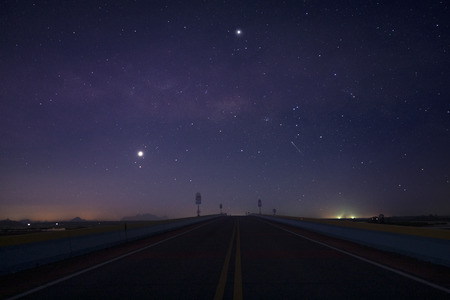 Landscape road in the night before sunrise with soft stars and grain.の写真素材