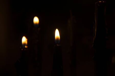 The flame of the candle glows in the night.の写真素材