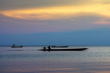 silhouette fishermans on the lake in twilight sky.の写真素材