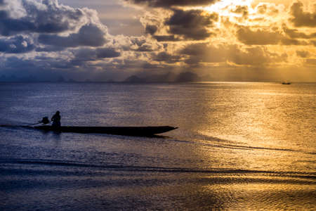 silhouette the fisherman and fishing boat on the lake with sunlight.