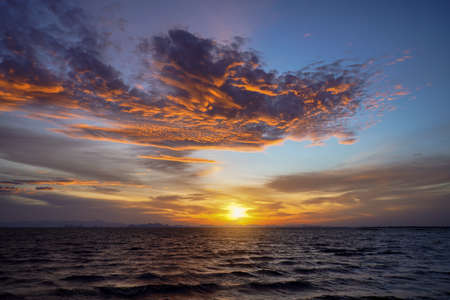 Sunset sky at the lake with clouds on the sky background.の写真素材