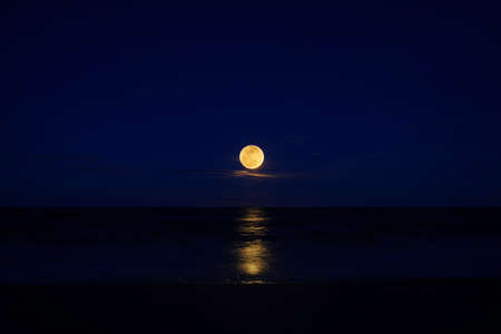 full moon on the beach in deep blue sky.の写真素材