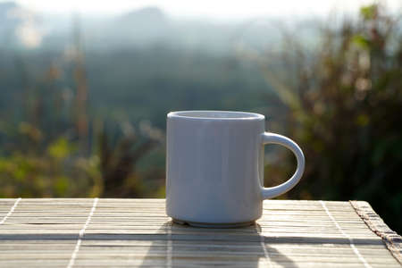Coffee mug at sunset with blurred backgroundの写真素材