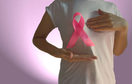 Vintage woman holding a pink ribbon breast cancer awareness Health care and medical concept isolated on pink background.の写真素材