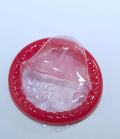 Red condom isolated on white background, sexually transmitted infection prevention concept and contraception.の写真素材
