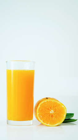 100% fresh-squeezed orange juice in a glass And citrus fruit split on white background. Concept of how to live with a naturally refreshing drink that contains vitamin C.の写真素材